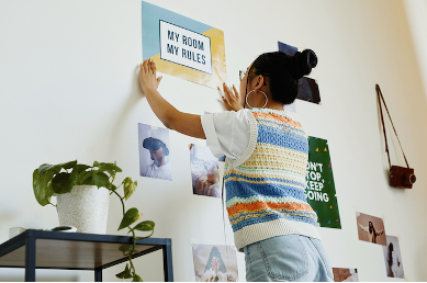 girl hanging up motivational poster
